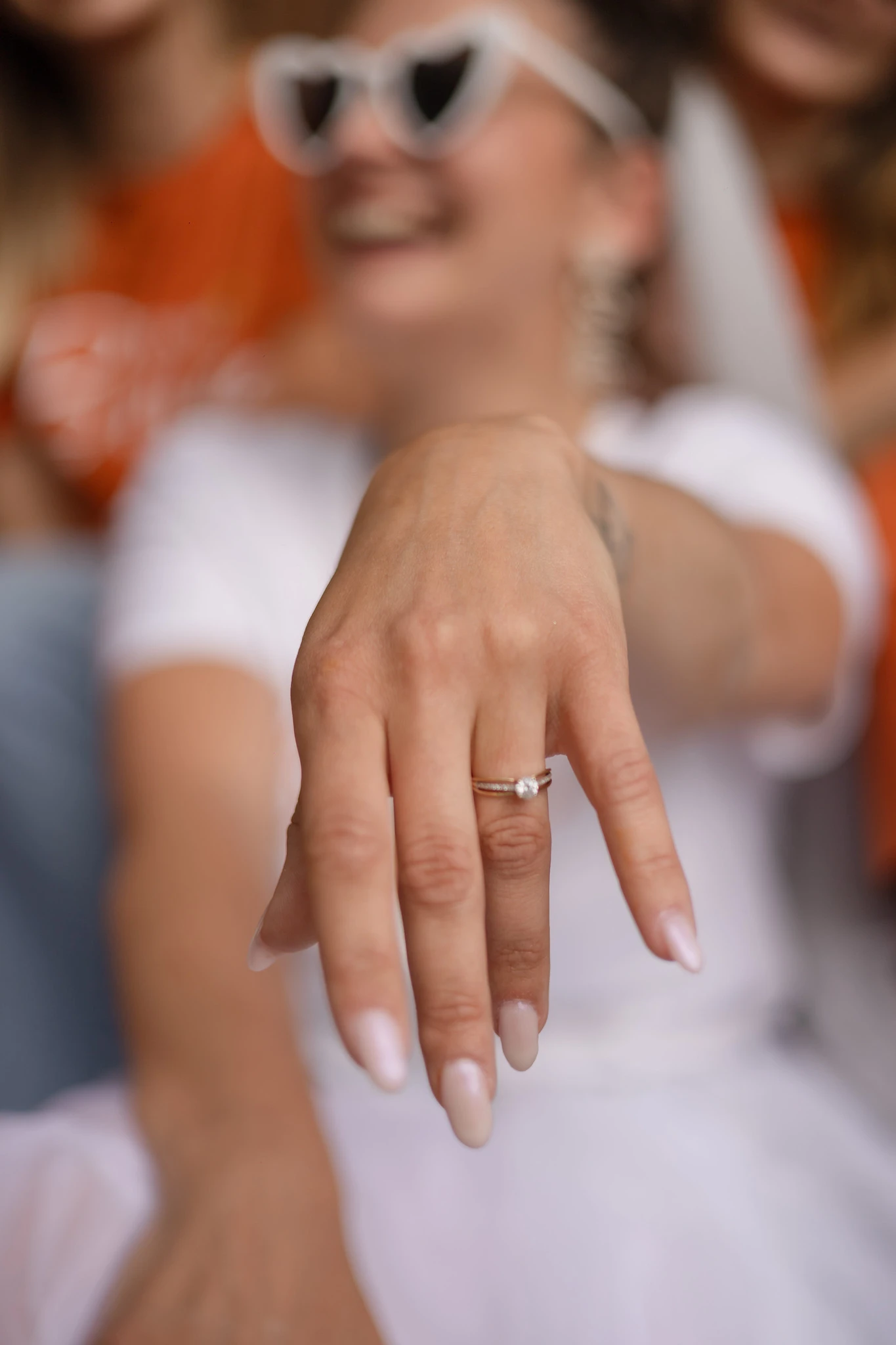 EVJF Lille – Focus sur la bague de fiançailles Main de la future mariée avec bague de fiançailles en avant-plan lors d’un EVJF à Lille, floutage artistique en arrière-plan