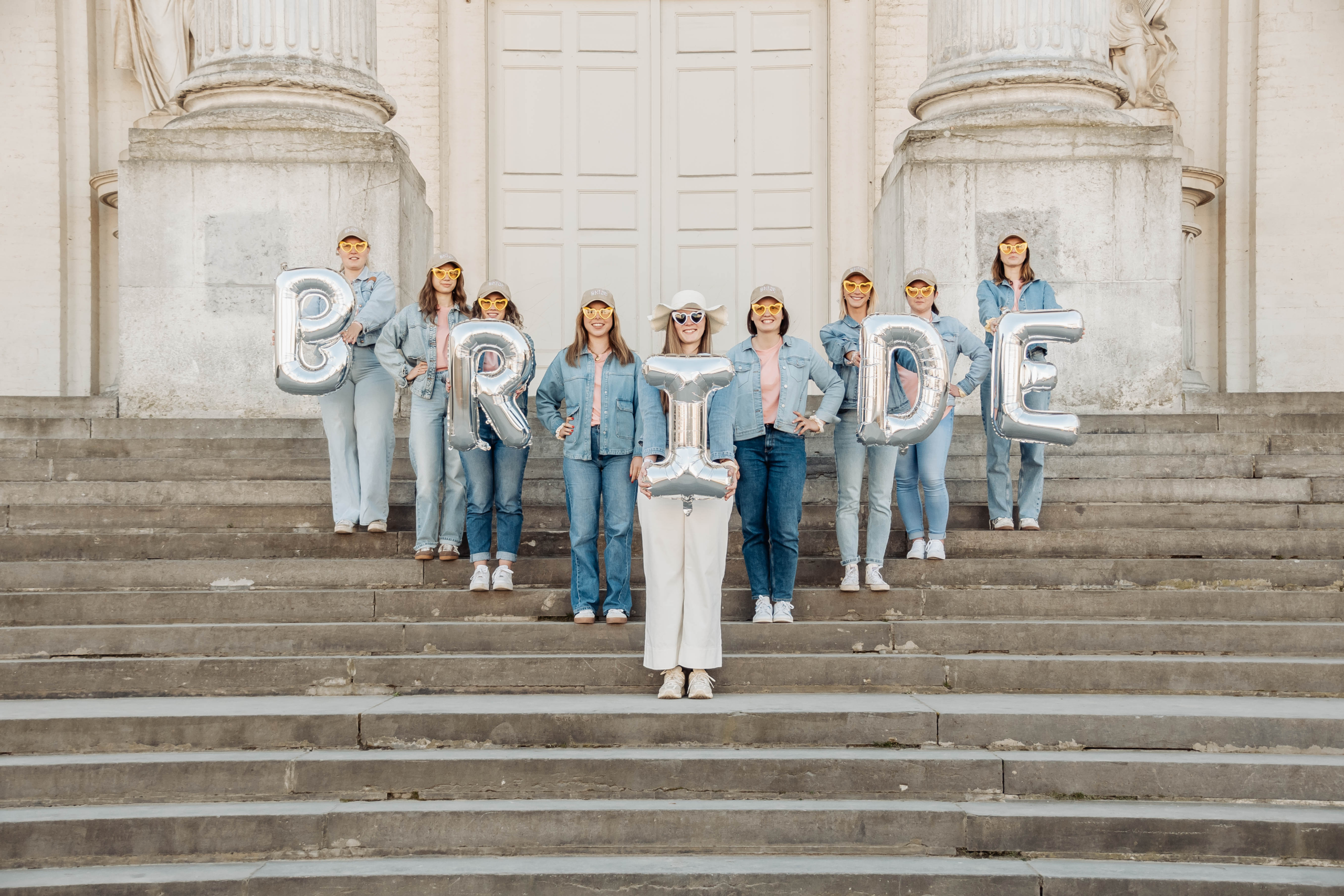 EVJF sur les marches d'une église à Bruxelles avec des ballons argentés