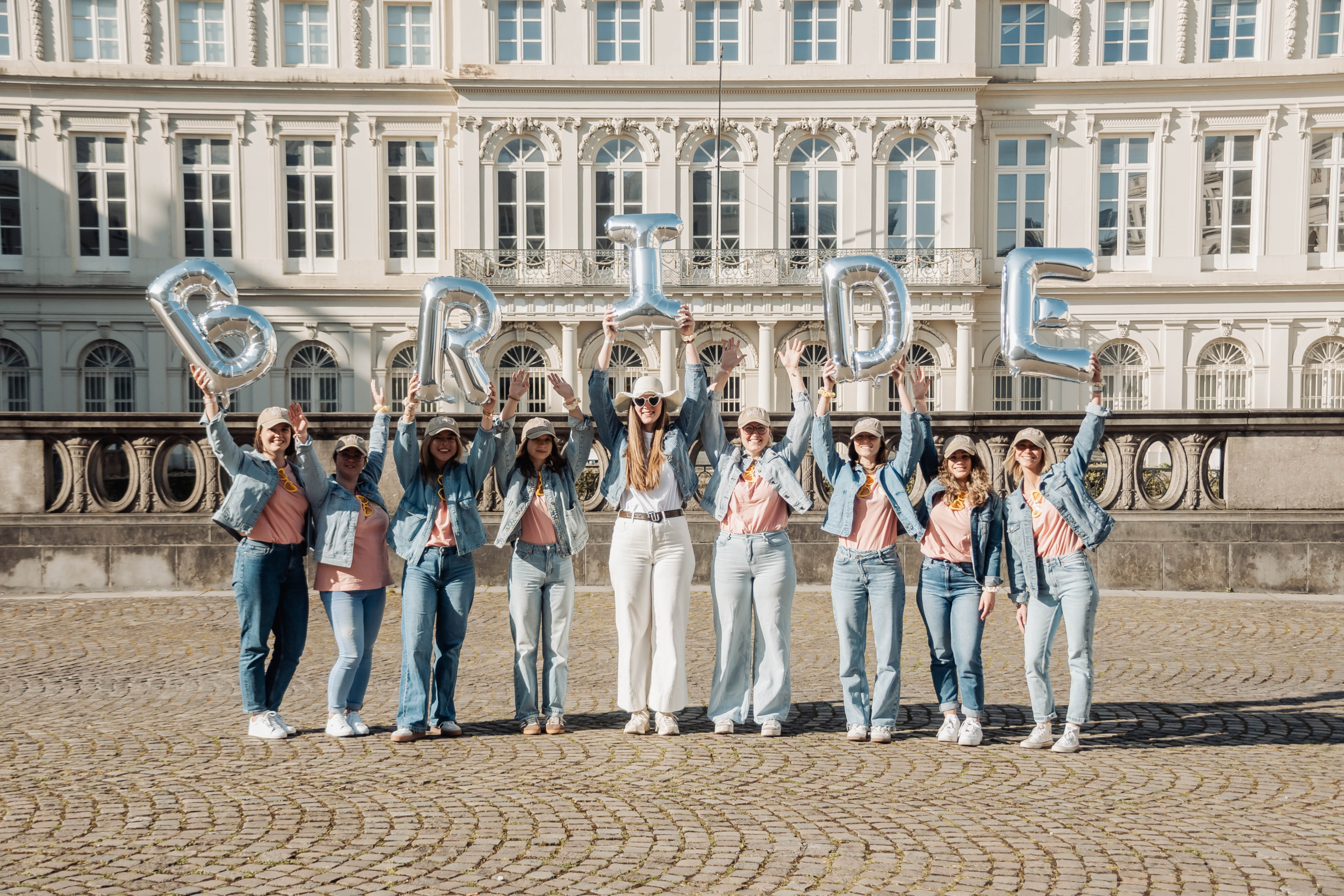 Filles tenant des ballons lettres 'BRIDE' dans les rues de Bruxelles