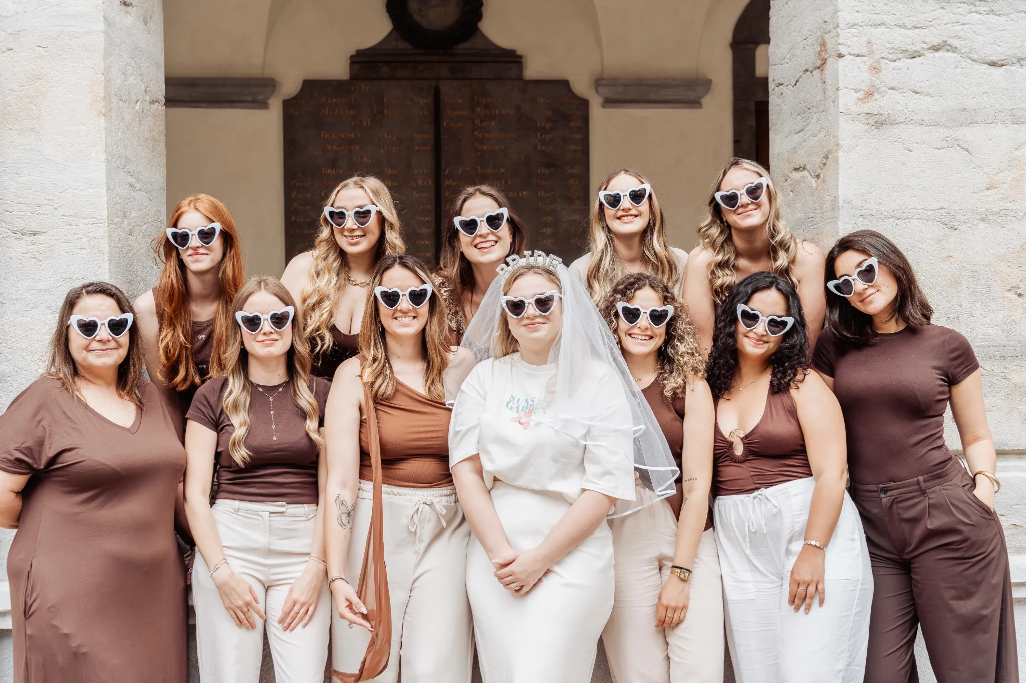 enterrement-vie-jeune-fille-lyon-groupe Photo de groupe lors d’un enterrement de vie de jeune fille à Lyon, toutes les participantes portent des lunettes en forme de cœur."