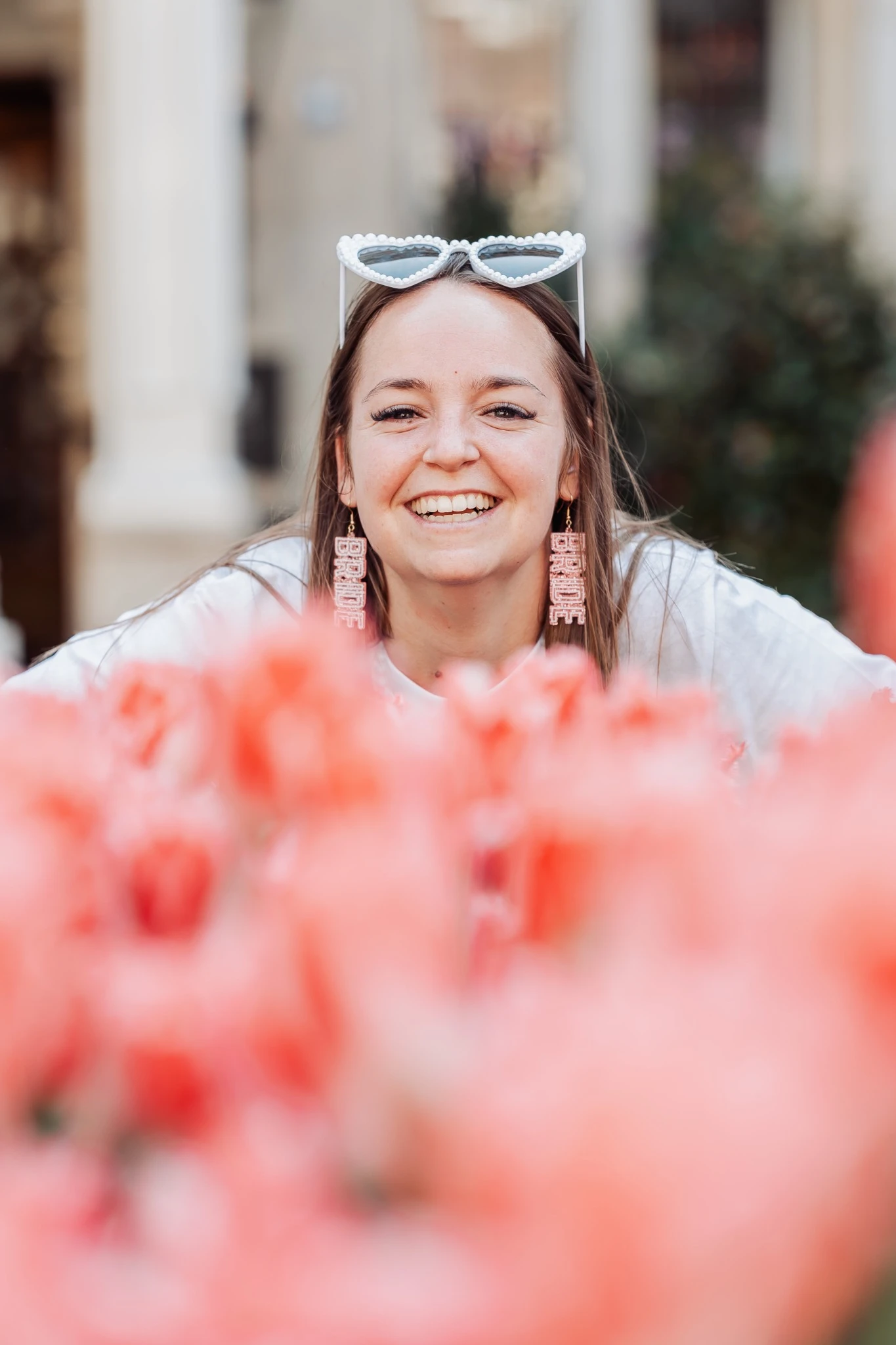 Portrait de la future mariée souriante à Amsterdam, posant devant des tulipes lors de son enterrement de vie de jeune fille.