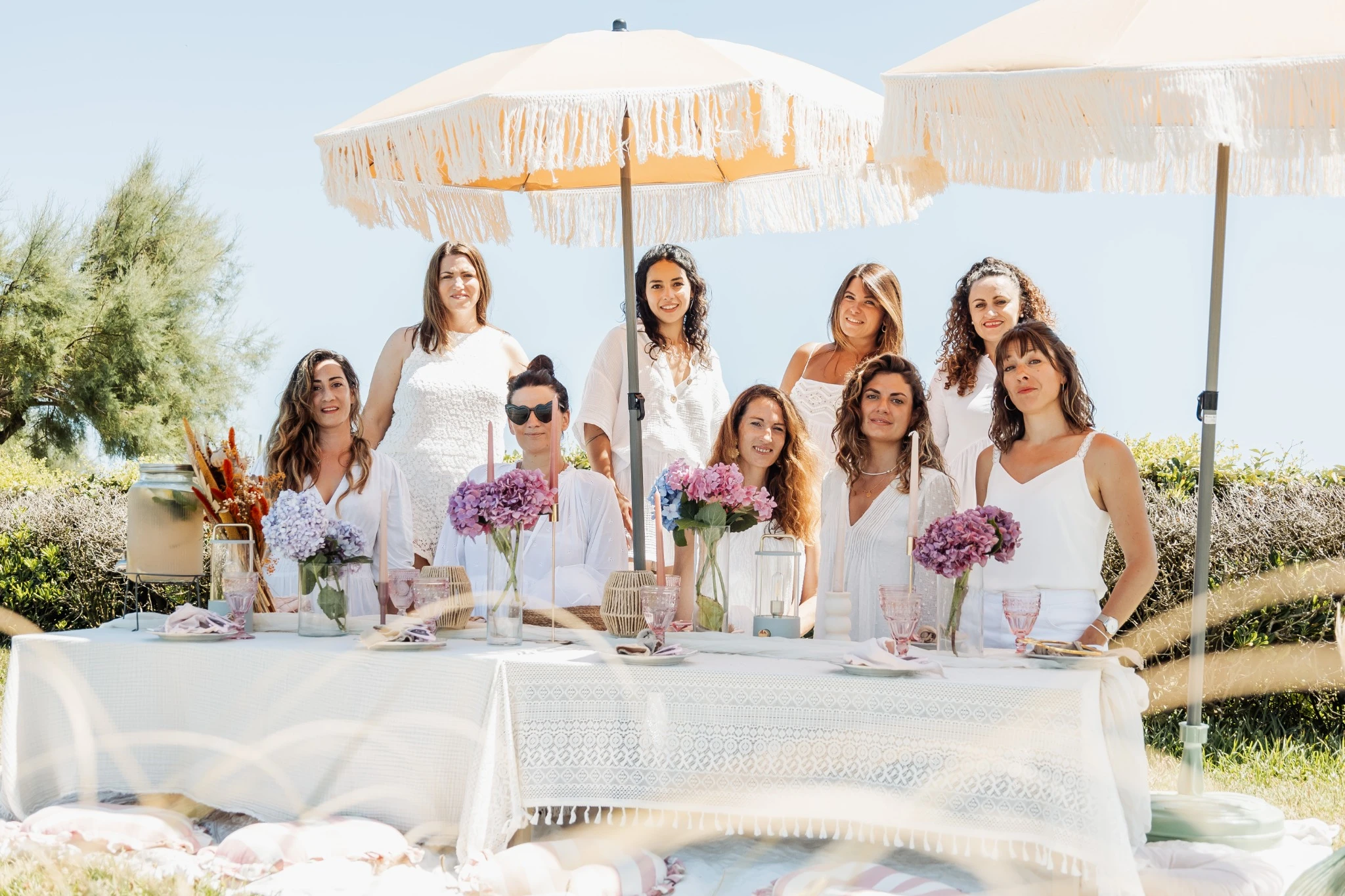 Brunch élégant d’enterrement de vie de jeune fille à Biarritz sous parasols avec décoration.