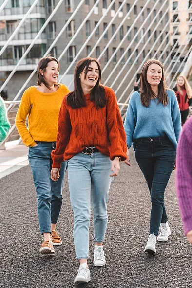 evjf-bilbao-marche-sur-le-pont-filles-colorees Groupe de filles marchant joyeusement sur le pont à Bilbao pendant un enterrement de vie de jeune fille