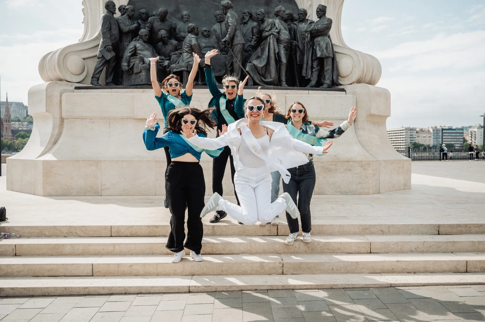 evjf-budapest-photo-saut-mariee-monument Saut de la future mariée et de ses amies lors d’un EVJF à Budapest devant le monument Kossuth