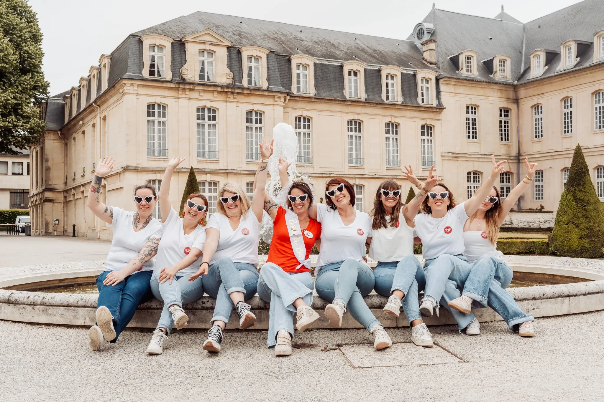 Photo EVJF à Caen – toutes les filles en ligne devant une fontaine, bras levés