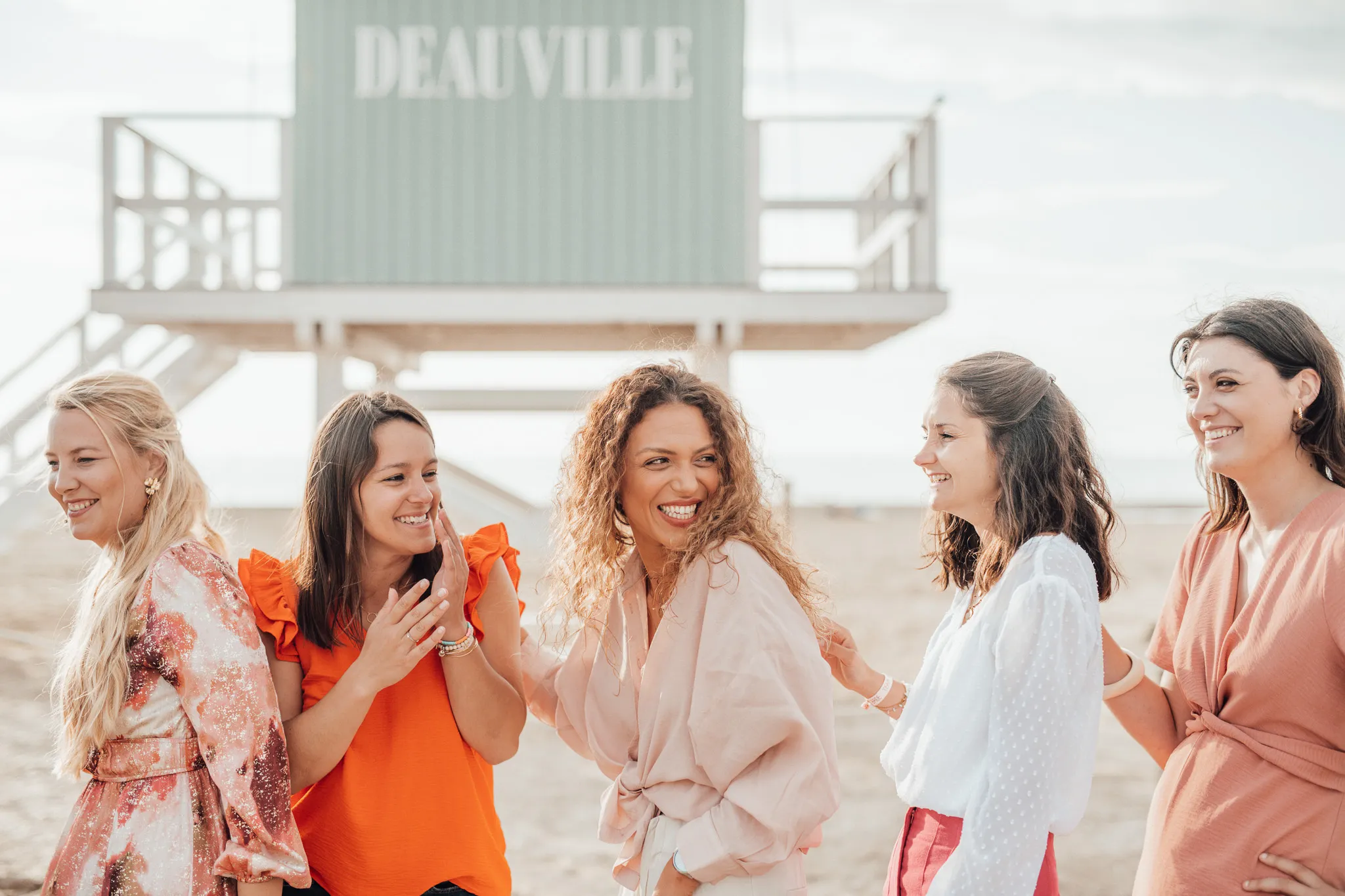 evjf-deauville-cabane-nom-ville EVJF à Deauville – Groupe de filles devant une cabane avec l’inscription Deauville, éclats de rire et bonne humeur