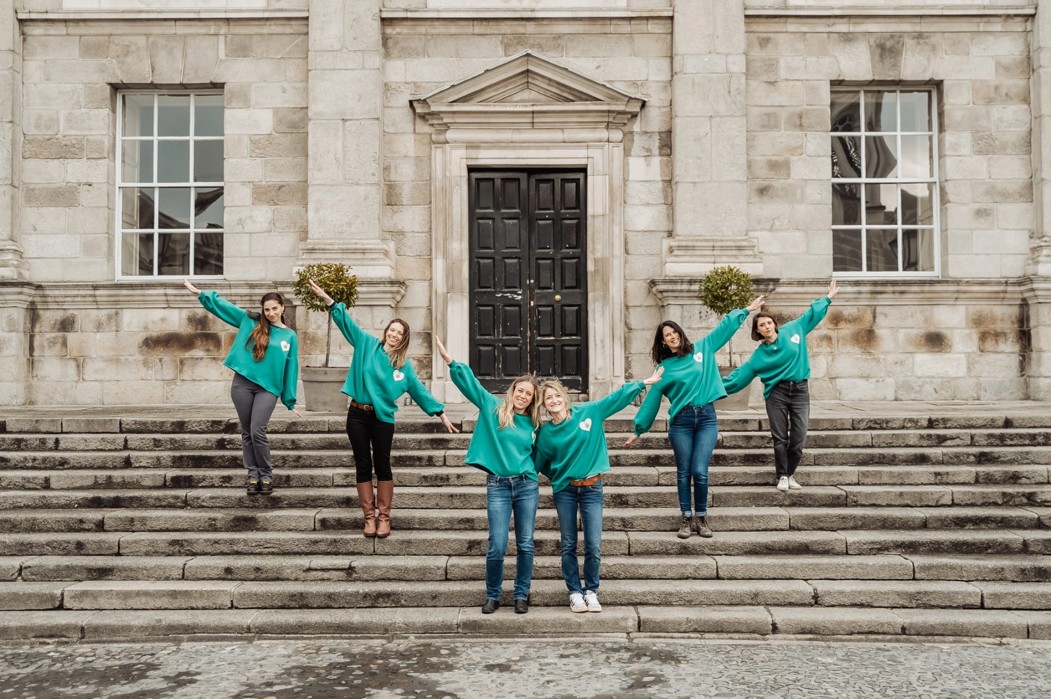 evjf-dublin-groupe-devant-escalier EVJF à Dublin – Groupe d’amies posant devant un bâtiment en pierre, ambiance joyeuse