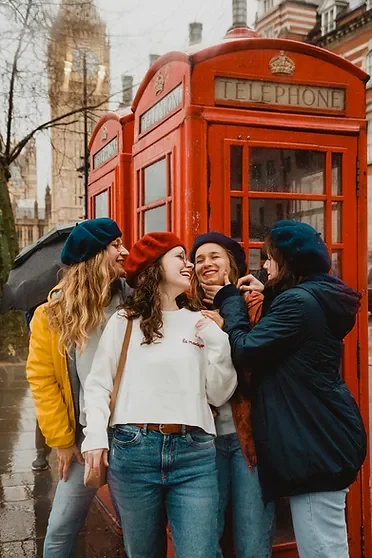 evjf-londres-cabine-telephone-rouge Enterrement de vie de jeune fille devant une cabine téléphonique rouge à Londres sous la pluie