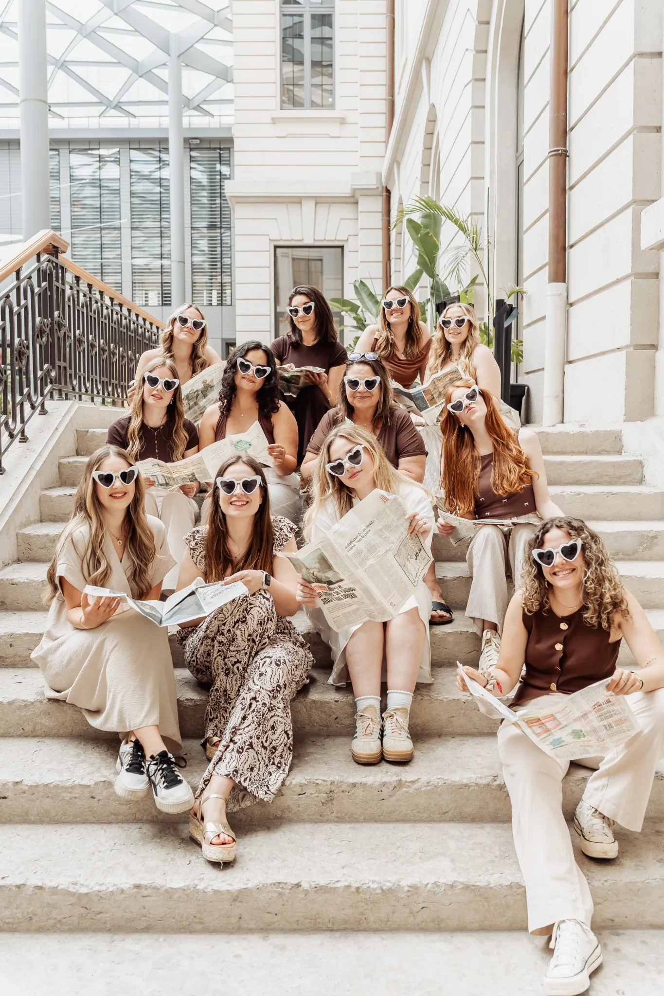 evjf-lyon-photos-groupe-stylees Photo stylée d’un groupe de femmes lisant des journaux sur des marches à Lyon lors d’un enterrement de vie de jeune fille