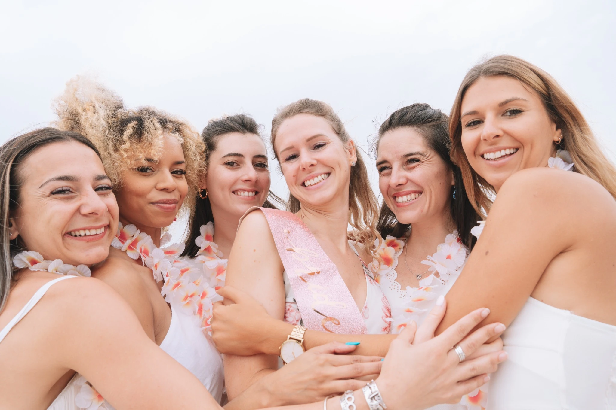 Photo rapprochée du groupe EVJF enlacé sur la plage à Majorque