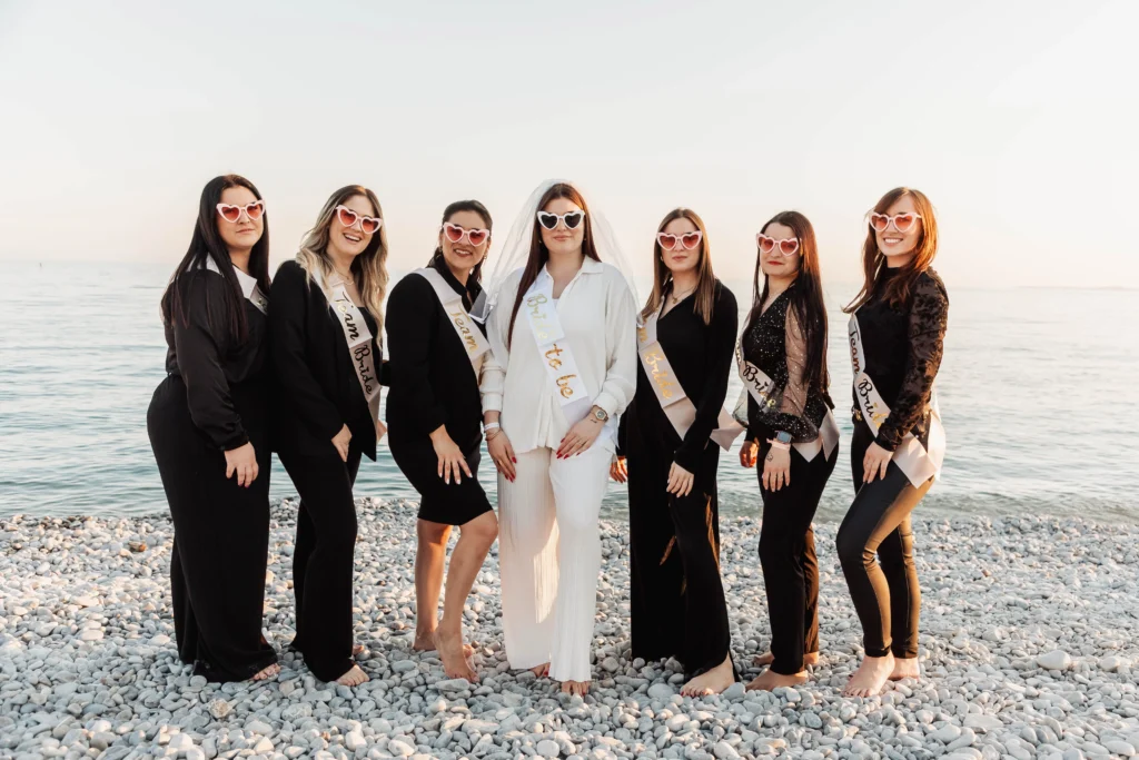 EVJF à Nice – La bride team en noir et blanc pose élégamment sur les galets au coucher du soleil