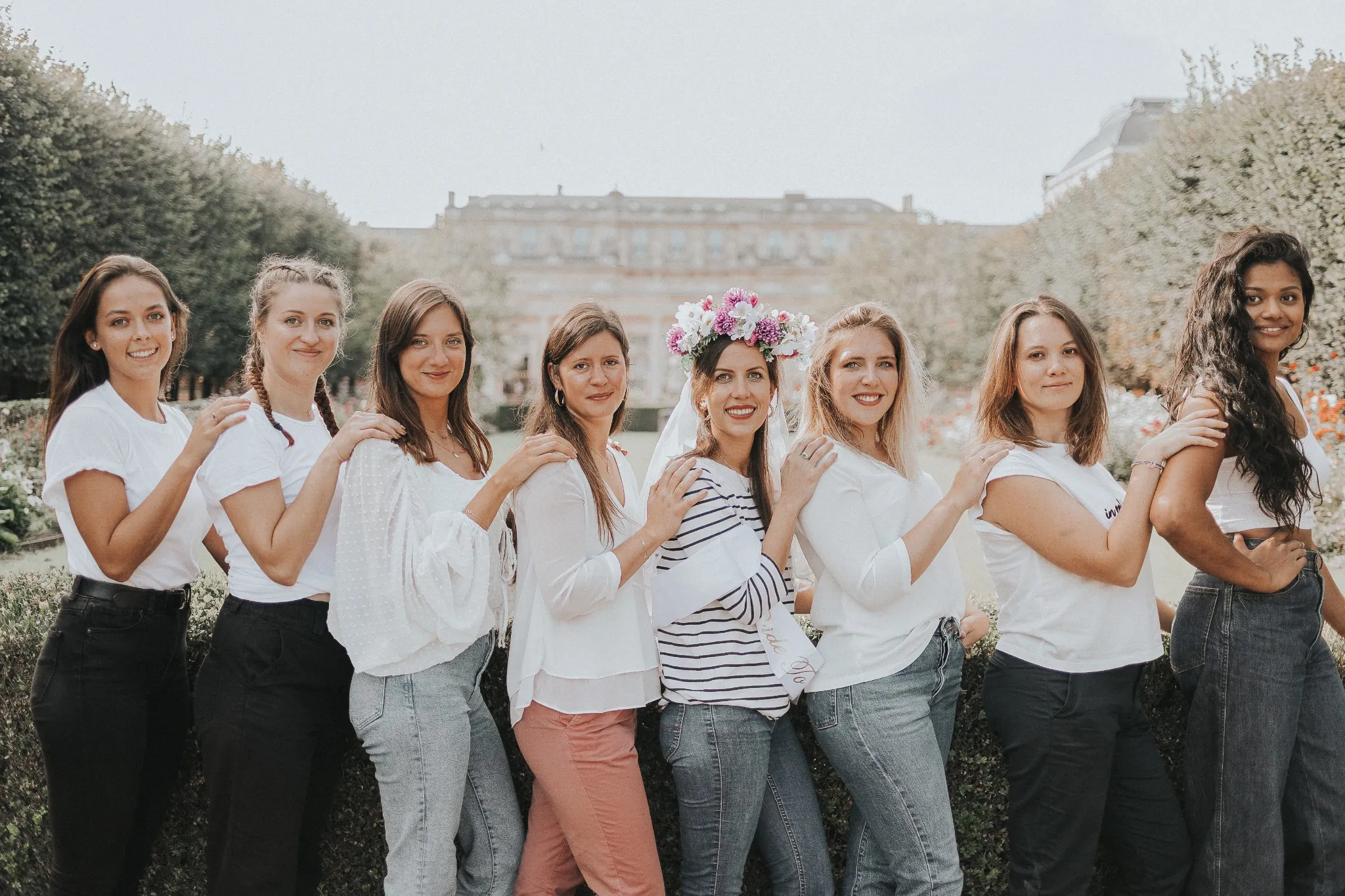 EVJF à Paris – Photo de groupe en file indienne dans un jardin fleuri, ambiance douce et naturelle