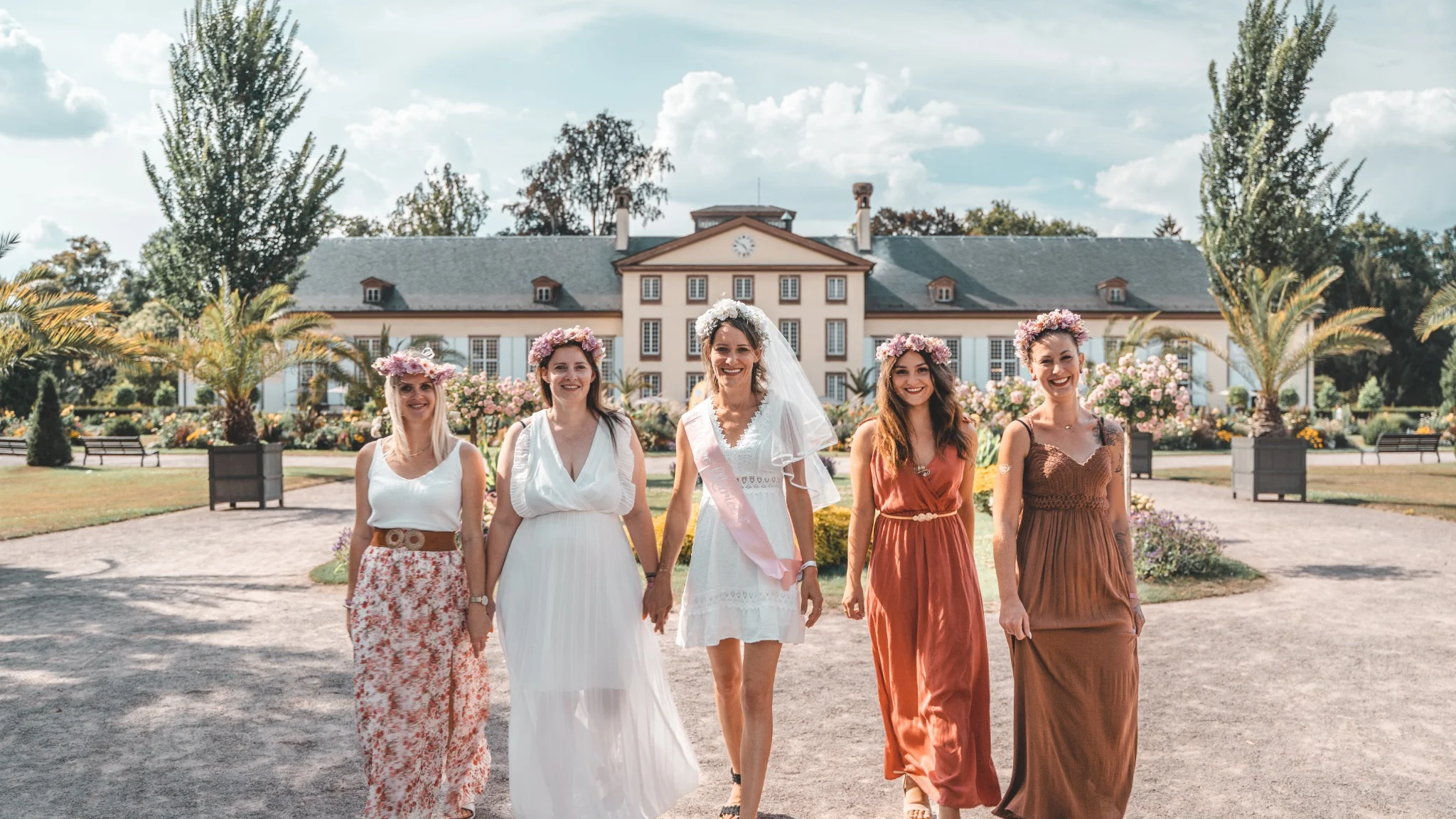 Groupe de filles marchant ensemble pour un EVJF à Strasbourg dans un parc ensoleillé