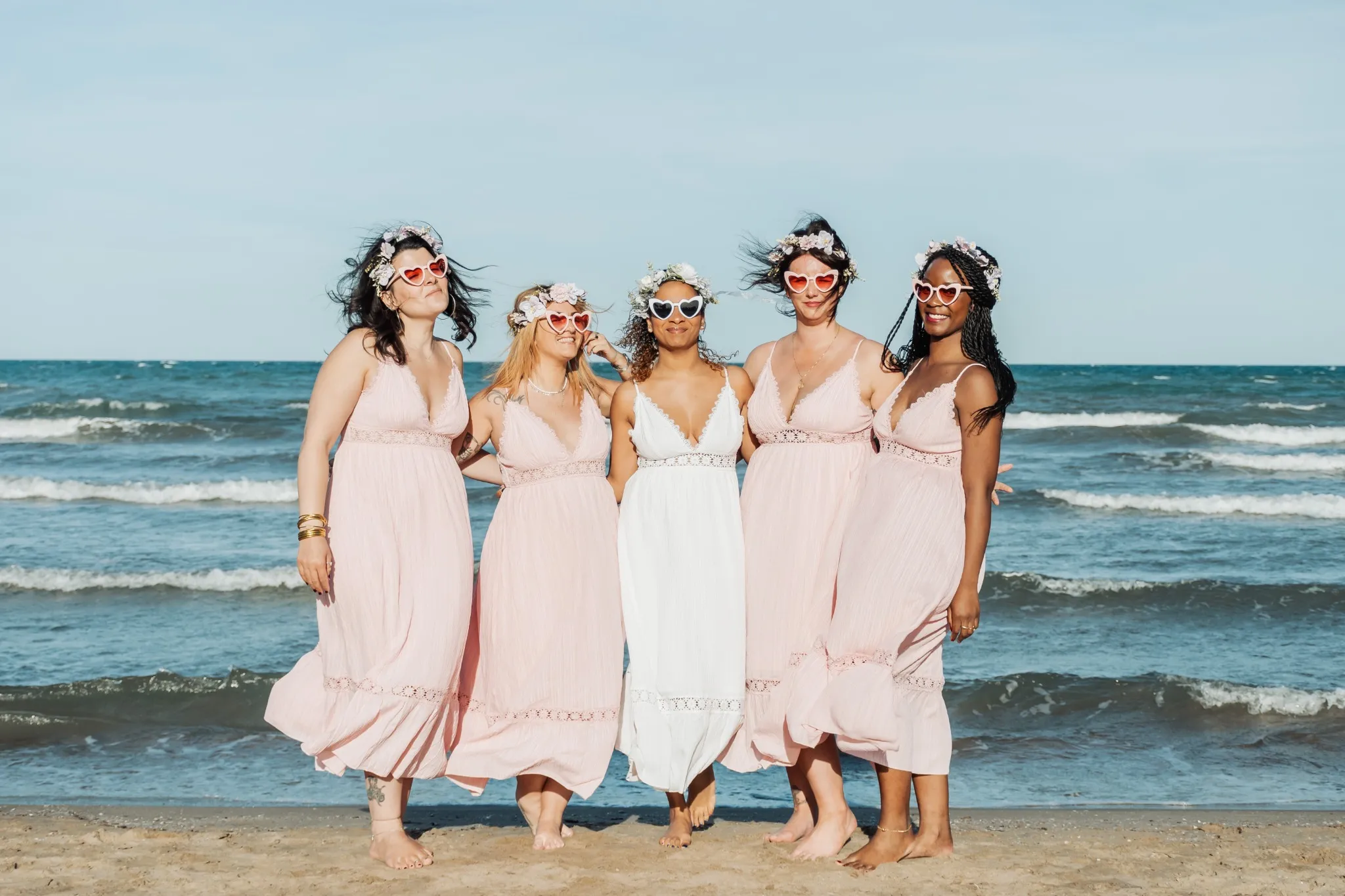Séance photo EVJF sur la plage à Valence avec lunettes cœur et robes roses