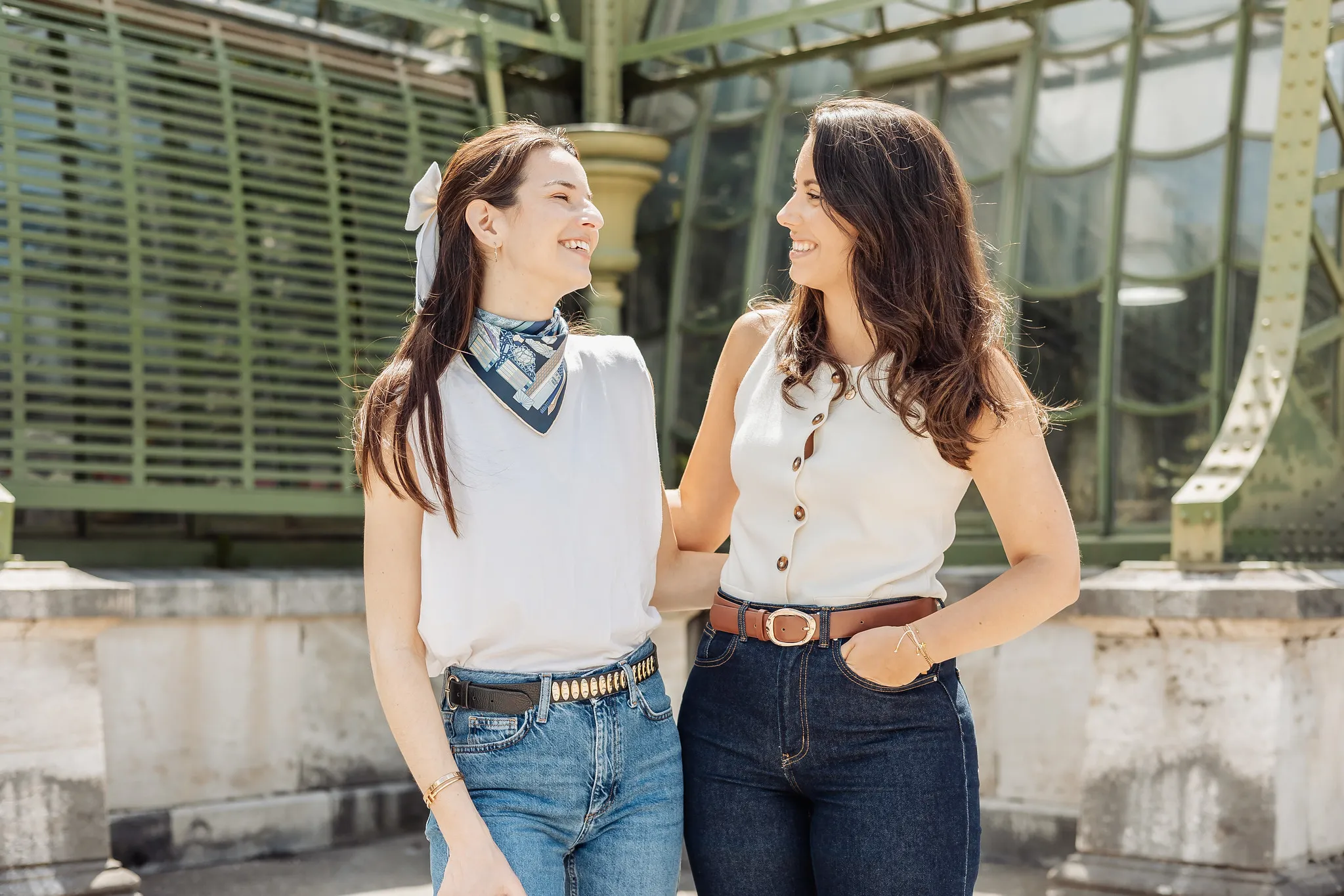 EVJF à Vienne – Duo complice devant la serre impériale Deux femmes se regardant avec le sourire devant une verrière verte à structure métallique, pendant un EVJF à Vienne.