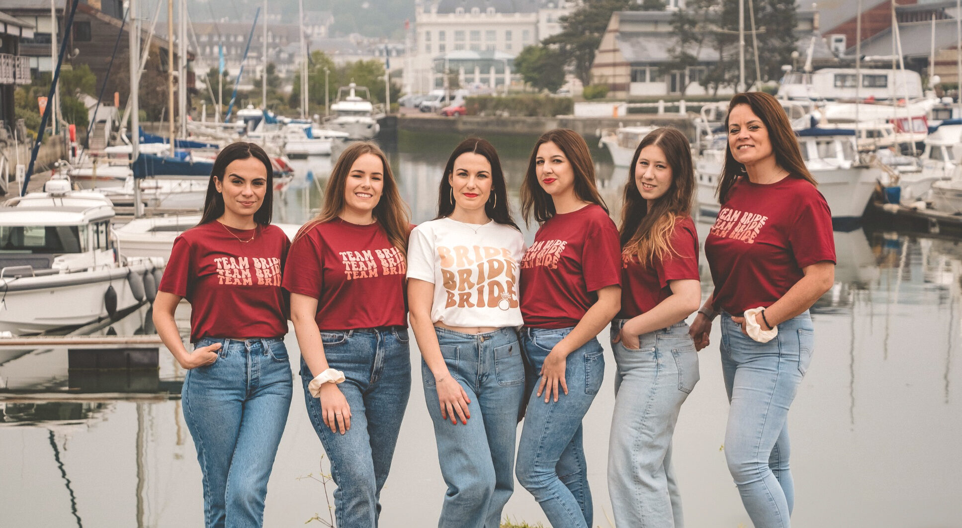 Photo de groupe EVJF à Honfleur avec la future mariée entourée de ses témoins au bord du port