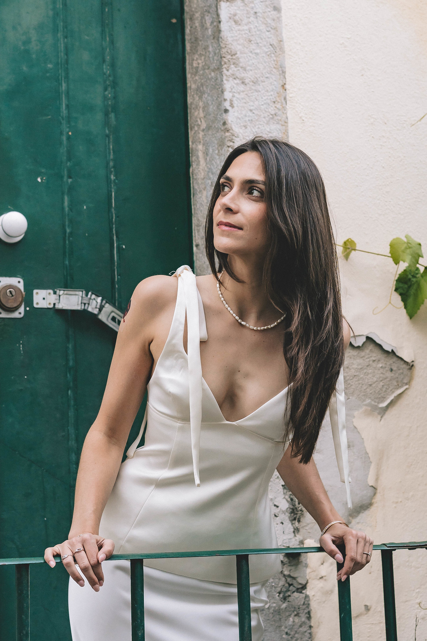 lisbonne-mariee-portrait Portrait de la mariée en robe blanche devant une porte verte à Lisbonne