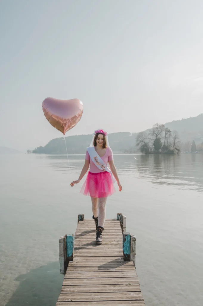 conseils evjf annecy Future mariée seule sur un ponton avec un ballon cœur rose à Annecy
