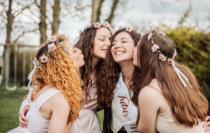 Photo EVJF à Bristol avec la future mariée rayonnante entourée de ses amies en robes pastel et couronnes de fleurs.