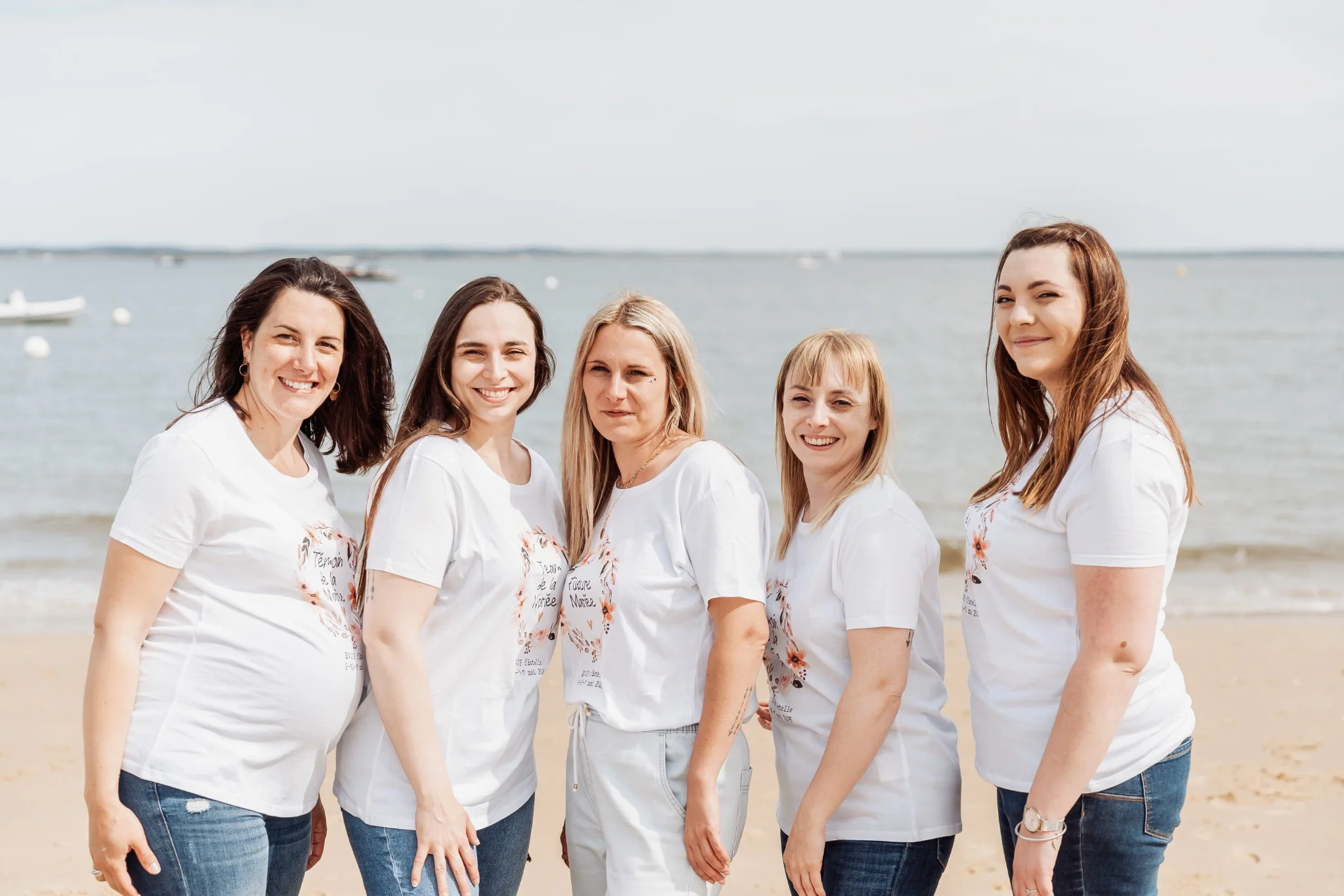 Photo de groupe EVJF à Antibes, les pieds dans le sable face à la mer